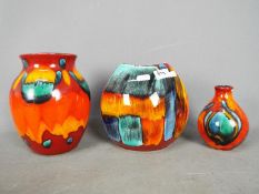 Poole Pottery - Three 'Delphis' series vases, largest approximately 20 cm (h).