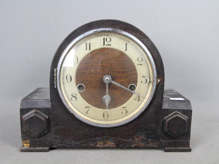 An oak cased mantel clock, Arabic numerals to the dial, with key and pendulum.