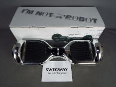 A Swegway two wheel self balancing electric scooter, contained in box, lacking charger.