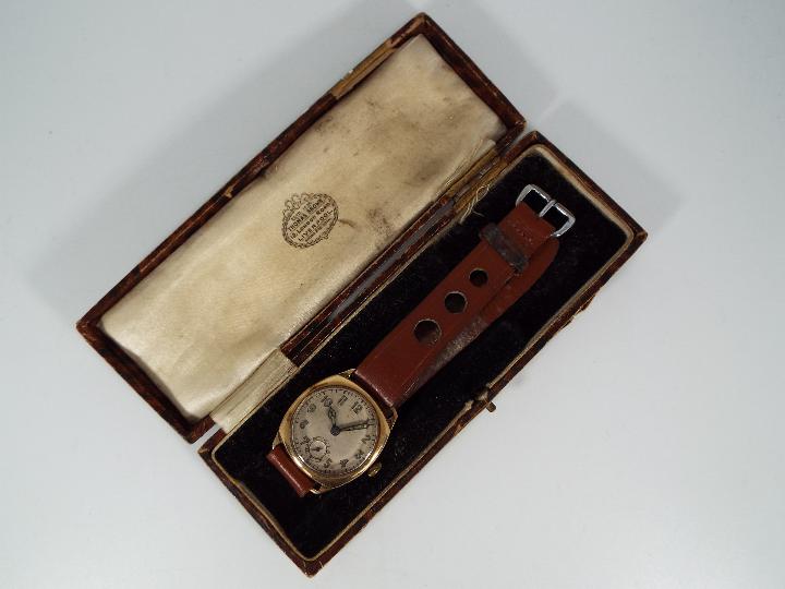 A gentleman's 9ct gold cased wristwatch on leather strap.