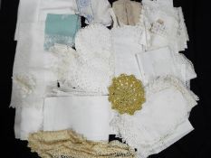 A box of vintage linen, doilies, table ware.