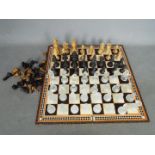 Three chess sets to include a glass set with 7.5 cm king and two wooden set, the larger with 8.