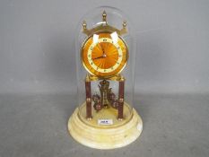 An Art Deco 400-day torsion clock in orange/ bronze lacquer finish,