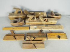 A collection of vintage hand tools, predominantly planes.