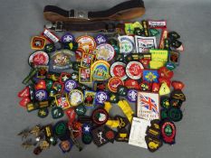 A collection of Girl Guide and Boy Scout badges and belts.