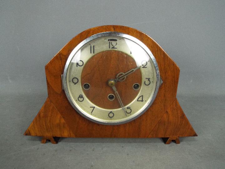A mantel clock, Arabic numerals to a silvered chapter ring, with key and pendulum.