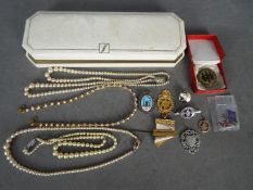 Lot to include pearl necklaces and a quantity of badges / medallions including a silver 'With