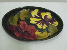 William Moorcroft "Hibiscus" Green oval dish, reds and yellows on a green ground.