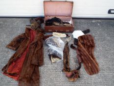 A vintage suitcase containing a quantity of furs,