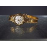 A lady's 9ct gold Accurist 21 jewel wristwatch on 9ct bracelet and safety chain (some splitting to