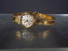 A lady's 9ct gold Accurist 21 jewel wristwatch on 9ct bracelet and safety chain (some splitting to