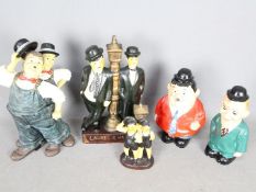A collection of Laurel & Hardy figurines and money banks.