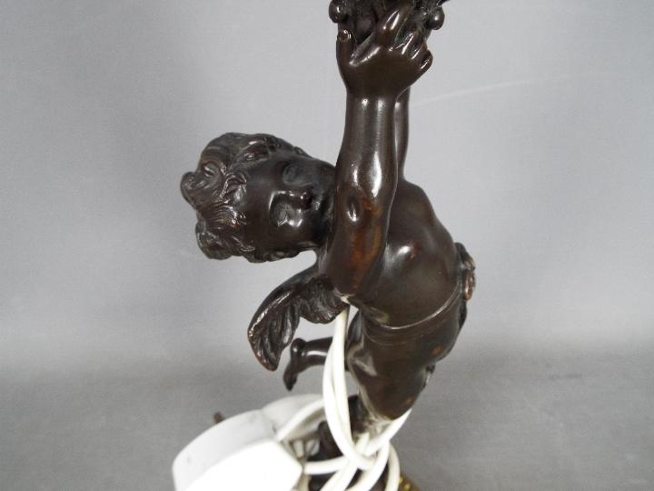 A decorative table lamp in the form of a standing putto, approximately 42 cm (h) including fitting. - Image 2 of 4