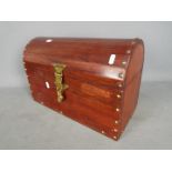 A small wooden dome top chest with brass fittings and felt lined interior,