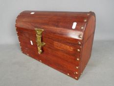A small wooden dome top chest with brass fittings and felt lined interior,