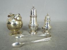 Two hallmarked silver cruets, a pair of silver tongs and a further twin section plated cruet.