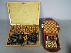 Two chess sets, one of an African tribal style and one other.