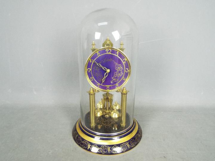 A Schatz 49 ‘Rosenthal’ model 400-day torsion clock in dark blue porcelain with decorative gilded