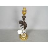 A decorative table lamp in the form of a standing putto, approximately 42 cm (h) including fitting.