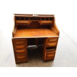 A roll top bureau, tambour top enclosing