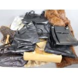 A collection of handbags and two fur coa