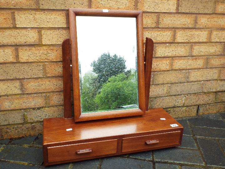 A table top swing mirror over two drawer