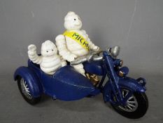 A cast iron Michelin man on a motorbike,