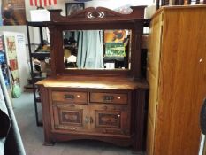 An oak mirror back sideboard, with carved Art Nouveau detail,