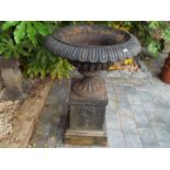 A Victorian cast iron campana urn on a matching cast iron base,