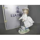 Lladro - a figurine entitled On the Go raised on a stepped wooden oval base # 6031 issued 1993-95,