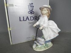 Lladro - a figurine entitled On the Go raised on a stepped wooden oval base # 6031 issued 1993-95,