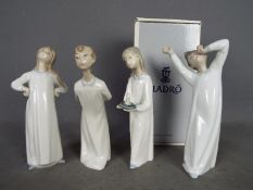 Lladro - Four Lladro figurines, one boxed, to include 'Boy Awaking', 'Girl With Candle' and similar,