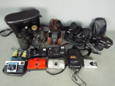 A quantity of cameras, binoculars and opera glasses.