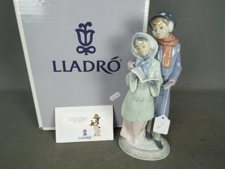 Lladro - A boxed Lladro figurine # 6218 Christmas Melodies depicting two carol singers,