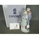 Lladro - A boxed Lladro figurine # 6218 Christmas Melodies depicting two carol singers,