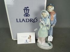 Lladro - A boxed Lladro figurine # 6218 Christmas Melodies depicting two carol singers,