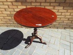 A circular tilt-top mahogany table,