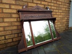 An over mantel mirror with carved decoration, approximately 85 cm x 100 cm x 13 cm.