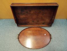 A butlers serving tray 69 cm x 44 cm and one other having brass handles.