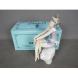 Lladro - A boxed figurine # 5615 Bathing Beauty, depicting a young girl sat upon a rock,