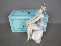 Lladro - A boxed figurine # 5615 Bathing Beauty, depicting a young girl sat upon a rock,