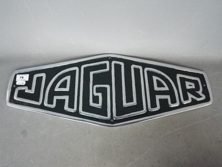 A white metal sign marked Jaguar,