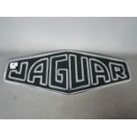 A white metal sign marked Jaguar,