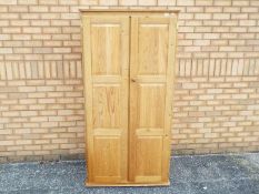 A pine twin door wardrobe measuring approximately 181 cm x 82 cm x 57 cm.