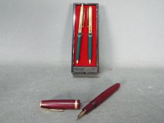 A Parker Duofold fountain pen with 14K nib, and a Papermate pen and pencil set.
