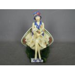 A Kevin Francis limited edition figurine depicting Charlotte Rhead seated and holding a vase,