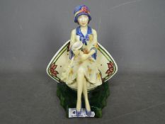 A Kevin Francis limited edition figurine depicting Charlotte Rhead seated and holding a vase,