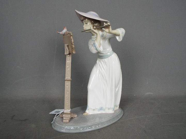Lladro - A boxed figurine # 6093 'Songbird', depicting a young girl playing the flute, - Image 2 of 4