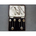 A George V cased set of six silver coffee spoons (tongs lacking) with bean terminals,