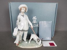 Lladro - A boxed figurine # 8522 Girl With French Bulldog depicting a young girl with shopping bags